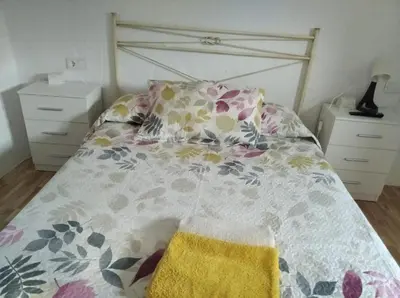 a bedroom with a bed with a floral bedspread at APARTAMENTO CAMPANA-6 in Jerez de la Frontera