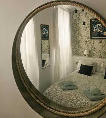 a round mirror in a room with a bed at Paraíso Malecón de Cádiz in Cádiz