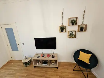 a living room with a tv and a chair at Paraíso Malecón de Cádiz in Cádiz