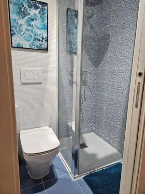 a bathroom with a toilet and a glass shower at Paraíso Malecón de Cádiz in Cádiz