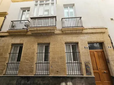 a building with barred windows and a wooden door at Paraíso Malecón de Cádiz in Cádiz
