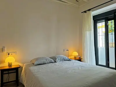 a bedroom with a bed with two lamps and a window at Casa Leopoldo - Ole Solutions in Bornos