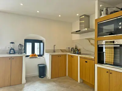 a large kitchen with wooden cabinets and a window at Casa Leopoldo - Ole Solutions in Bornos