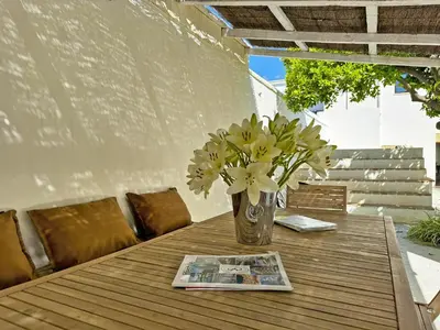 a vase of flowers on a table with a newspaper at Casa Leopoldo - Ole Solutions in Bornos