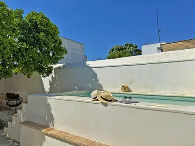 two hats sitting on a wall next to a swimming pool at Casa Leopoldo - Ole Solutions in Bornos