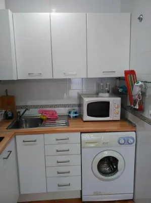 a kitchen with a washing machine and a microwave at Piscina y garaje a 300 m de playa OJO VER CORREO NO DESEADO SI NO LLEGA RESPUESTA in Rota