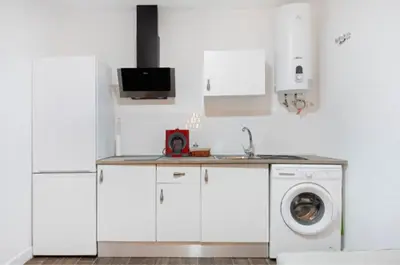 a kitchen with white cabinets and a washing machine at APARTAMENTO BRIANNA in Jerez de la Frontera