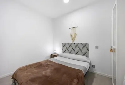 a bedroom with a large bed in a white room at APARTAMENTO BRIANNA in Jerez de la Frontera