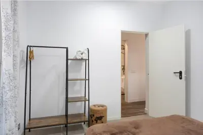 a room with a bed and a mirror and a shelf at APARTAMENTO BRIANNA in Jerez de la Frontera