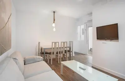 a white living room with a white couch and a table at APARTAMENTO BRIANNA in Jerez de la Frontera