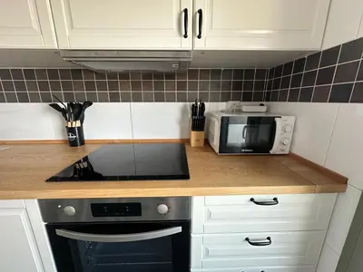 a kitchen with a stove top oven next to a microwave at Apartamento Jardín de Cano - Preferente familias y mayores de 25 años in El Puerto de Santa María