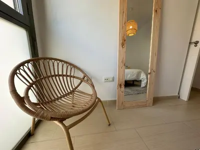 a chair in a room with a mirror at Apartamento Jardín de Cano - Preferente familias y mayores de 25 años in El Puerto de Santa María