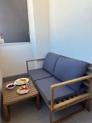 a blue couch and a table with a plate of food at Apartamento Jardín de Cano - Preferente familias y mayores de 25 años in El Puerto de Santa María
