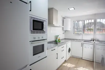 a white kitchen with a sink and a microwave at Chiclana.Balconera.1ªlínea playa in Chiclana de la Frontera