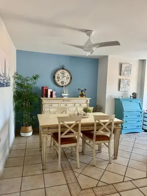 a dining room with a table and a clock on the wall at Apartamento con vistas al mar in Rota