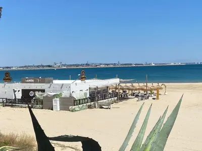 a building on a beach next to the water at Apartamento con vistas al mar in Rota