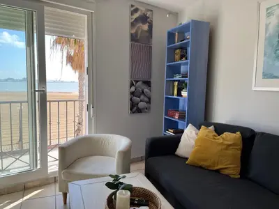 a living room with a blue couch and a chair at Apartamento con vistas al mar in Rota