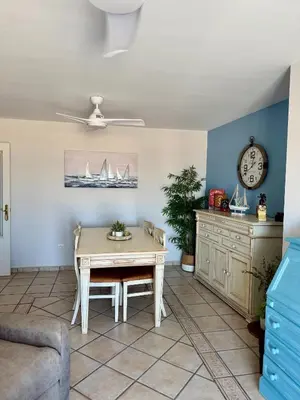 a living room with a table and a clock at Apartamento con vistas al mar in Rota
