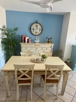 a table with two chairs and a clock on a wall at Apartamento con vistas al mar in Rota