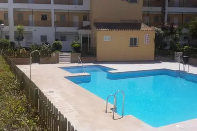 a living room with a couch and a mirror at Apartamento en Costa Ballena a 50 metros playa. in Rota