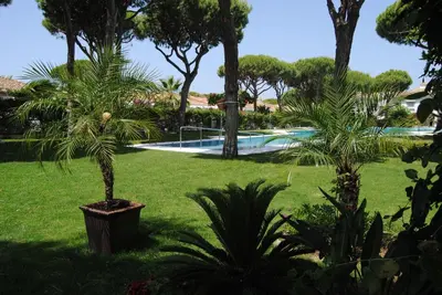 a park with a swing set and a tree at Chiclana Costa in Chiclana de la Frontera