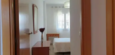 a living room with an orange couch and a table at Chiclana Costa in Chiclana de la Frontera