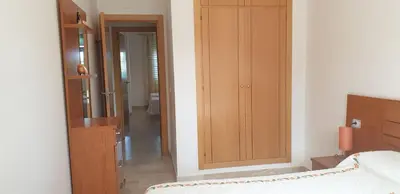 a hallway with two beds in a room with a window at Chiclana Costa in Chiclana de la Frontera