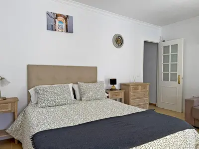 two beds in a room with blue curtains at Apartamento Las Ninas - Ole Solutions in El Puerto de Santa María