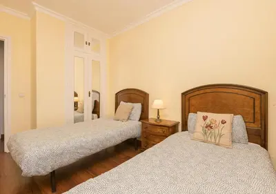 a bedroom with two beds and a table with a lamp at El Trebol in El Puerto de Santa María