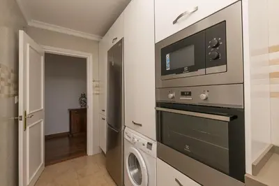 a kitchen with a microwave and a washer and dryer at El Trebol in El Puerto de Santa María