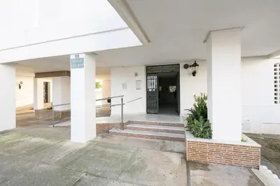 a front entrance of a white building with a door at El Trebol in El Puerto de Santa María