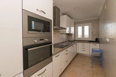 a kitchen with white cabinets and a stove top oven at El Trebol in El Puerto de Santa María