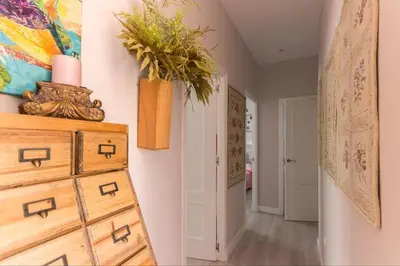a hallway with a dresser with a plant on it at Apartamento planta baja con piscina privada a 50 m de la playa in Sanlúcar de Barrameda