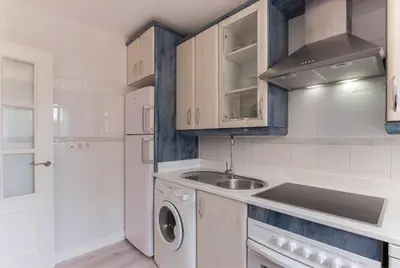 a kitchen with a sink and a washing machine at Apartamento planta baja con piscina privada a 50 m de la playa in Sanlúcar de Barrameda