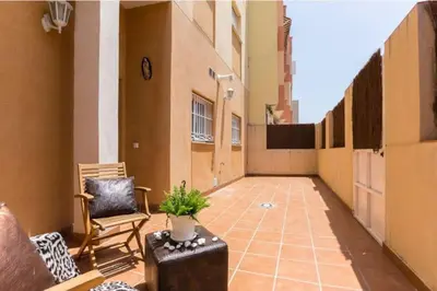 an empty balcony with a chair and a plant at Apartamento planta baja con piscina privada a 50 m de la playa in Sanlúcar de Barrameda