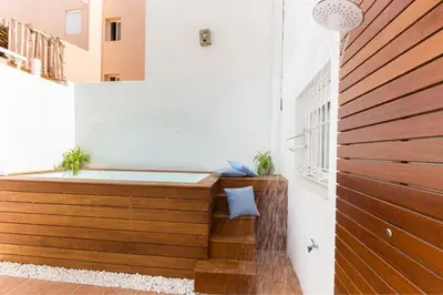 a bath tub in a room with a wooden wall at Apartamento planta baja con piscina privada a 50 m de la playa in Sanlúcar de Barrameda