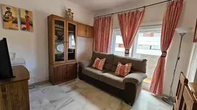 a living room with a couch and a window at Infanta Isabel petfriendly by Sanlúcar Housing in Sanlúcar de Barrameda
