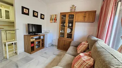 a living room with a couch and a tv at Infanta Isabel petfriendly by Sanlúcar Housing in Sanlúcar de Barrameda
