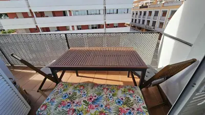 a wooden table and chairs on a balcony with a table at Infanta Isabel petfriendly by Sanlúcar Housing in Sanlúcar de Barrameda