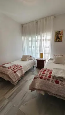 a bedroom with two beds and a window at Infanta Isabel petfriendly by Sanlúcar Housing in Sanlúcar de Barrameda