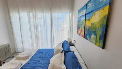a bedroom with a bed with a painting on the wall at Infanta Isabel petfriendly by Sanlúcar Housing in Sanlúcar de Barrameda