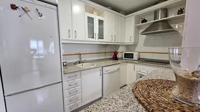 a kitchen with a white refrigerator and a sink at Infanta Isabel petfriendly by Sanlúcar Housing in Sanlúcar de Barrameda
