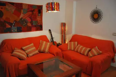 a living room with two orange couches and a table at Apartamento cerca del centro in Jerez de la Frontera