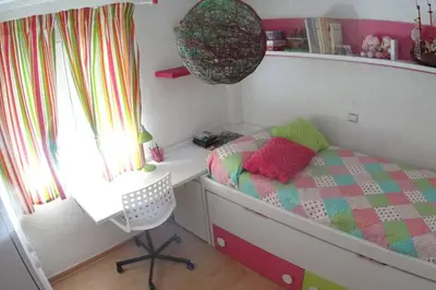a childs bedroom with a bed and a chair at Apartamento cerca del centro in Jerez de la Frontera