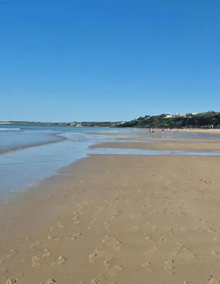 a beach with footprints in the sand and the water at Santa Catalina primera línea de mar con vistas a Cádiz in El Puerto de Santa María