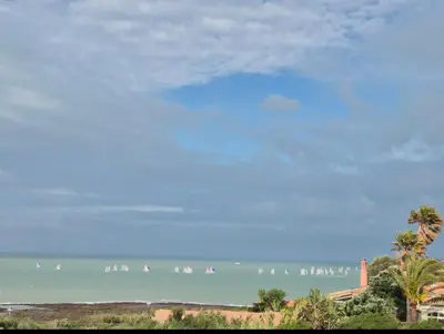 a group of people surfing in the ocean at Santa Catalina primera línea de mar con vistas a Cádiz in El Puerto de Santa María