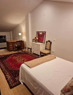 a bedroom with a bed and a desk and a table at Santa Catalina primera línea de mar con vistas a Cádiz in El Puerto de Santa María