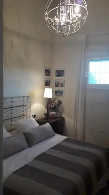 a bedroom with a large bed and a chandelier at Viña Santa Petronila Torre in Jerez de la Frontera
