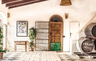 a door to a wine tasting room with barrels at Viña Santa Petronila Torre in Jerez de la Frontera