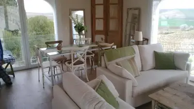 a living room with a white couch and a table at Viña Santa Petronila Torre in Jerez de la Frontera